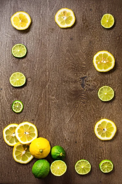 sliced lemon, lime on  slate and wooden counter top background