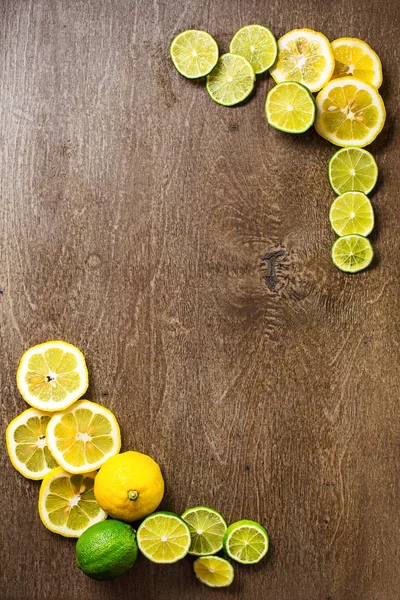 sliced lemon, lime on  slate and wooden counter top background