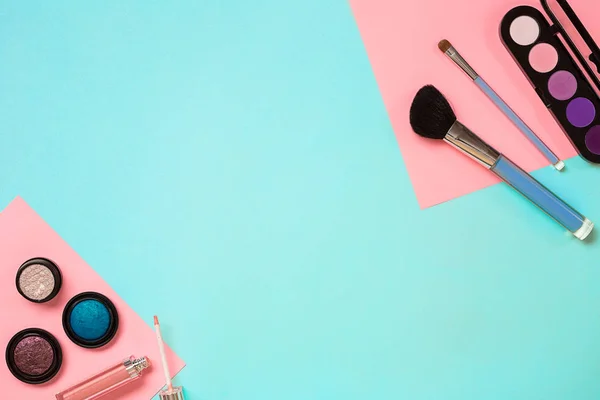 Inventa o essencial. Conjunto de escovas de maquiagem profissional, cremes e sombras em frascos no fundo azul . — Fotografia de Stock