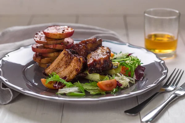 Гарячі м'ясні страви. Свинячі ребра на грилі з салатом та яблуками на тарілці . — стокове фото