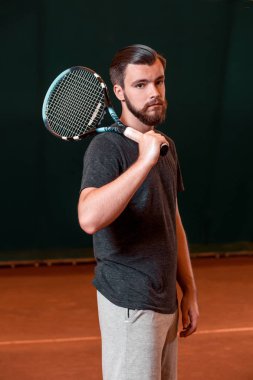 Raket tenis kortunda ile t-shirt yakışıklı genç adam