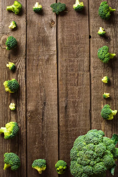 Brócoli sobre pizarra y fondo de encimera de madera — Foto de Stock