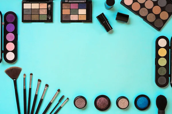 Vários cosméticos e escovas no fundo azul — Fotografia de Stock