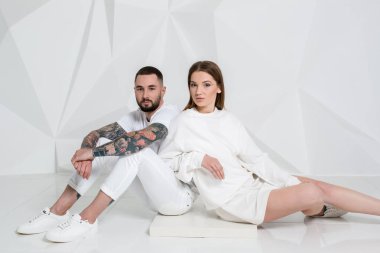 Güzel genç bir çift aşık stüdyoda beyaz arka plan üzerinde poz portresi.