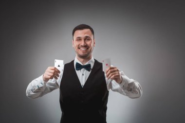 Gömlek ve yelek genç adam onun poker kartları, atış studio gösterir