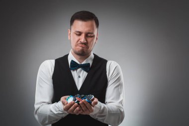 Gömlek ve yelek genç adam poker fişleri, atış studio gösterir