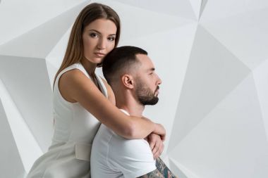 Güzel genç bir çift aşık stüdyoda beyaz arka plan üzerinde poz portresi.