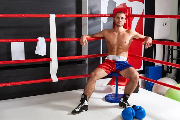 Yüzüğü köşede oturmuş yorgun erkek boxer