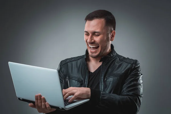 Hombre feliz sosteniendo portátil sobre fondo gris — Foto de Stock
