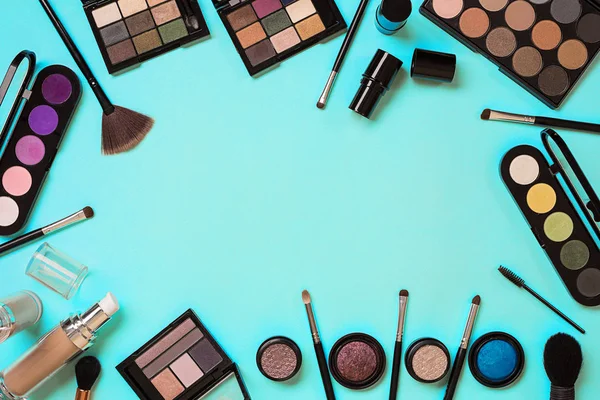 Vários cosméticos e escovas no fundo azul — Fotografia de Stock