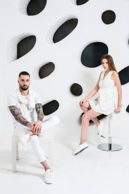 Yakınındaki bir beyaz duvar, erkek ve kadın beyaz giyim rahat Çift.