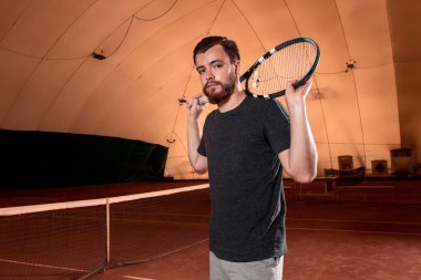 Raket tenis kortunda ile t-shirt yakışıklı genç adam