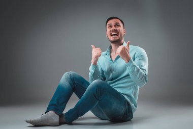 Kamera gülümseyen seyir katta oturan rahat genç adam çekici