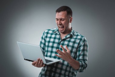 Çekici adam model laptop ile çalışma, bir şey gösterilen gri üzerine sol tarafından izole Yeşil tişörtlü.