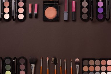 Çeşitli kozmetik ve fırçalar kahverengi zemin üzerine
