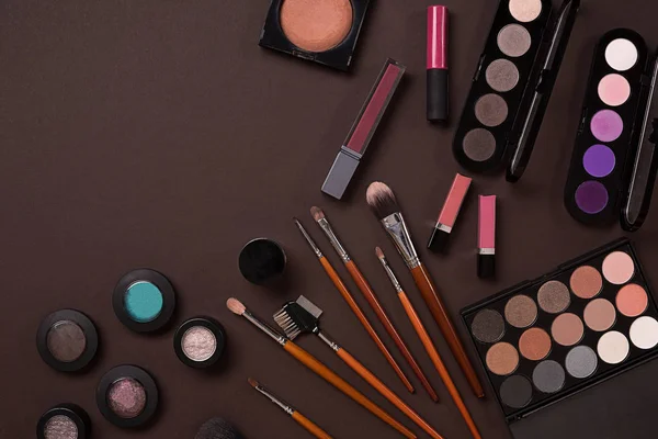 Ovanifrån på uppsättning av kosmetika för professionell make-up på brun bakgrund — Stockfoto