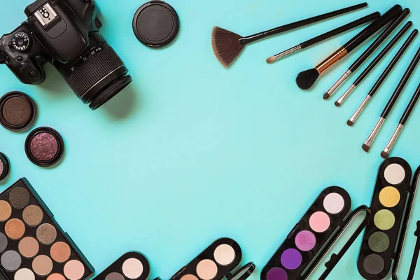 Inventa o essencial. Conjunto de escovas de maquiagem profissional, cremes e sombras em frascos no fundo azul . — Fotografia de Stock