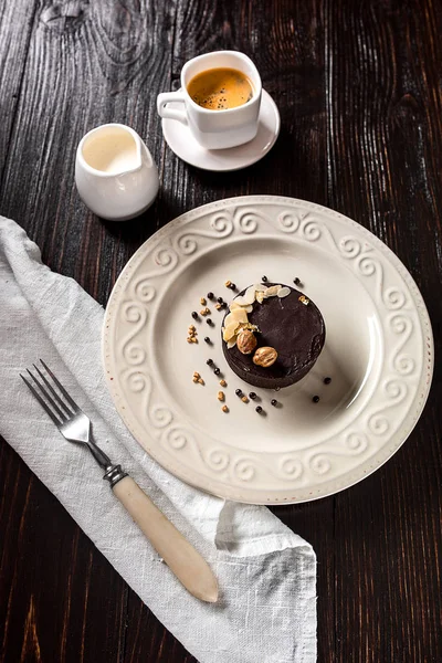 Güzel dekore edilmiş altın fındık ve bir fincan kahve ile çikolatalı kek