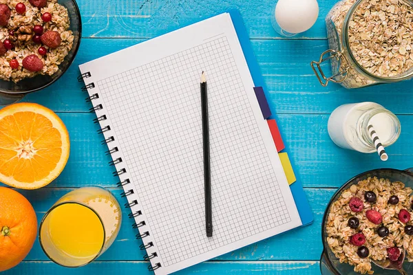 Mavi ahşap arka plan, üstten görünüm kaşık süt ve meyve bir kase ile yulaf gevreği