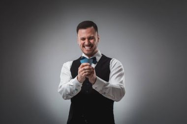 Gömlek ve yelek genç adam onun poker kartları, stüdyo çekim izle