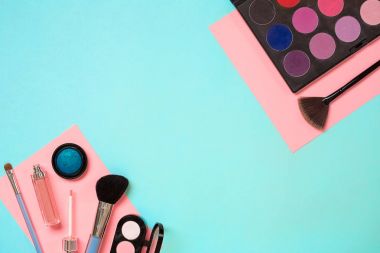 Gerekli kadar olun. Fırçalar, kremler ve gölgeler kavanoz mavi zemin üzerine profesyonel makyaj seti.