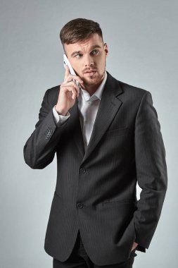 Telefon görüþmesi gri arka plan karşı bir yakışıklı işadamı portresi