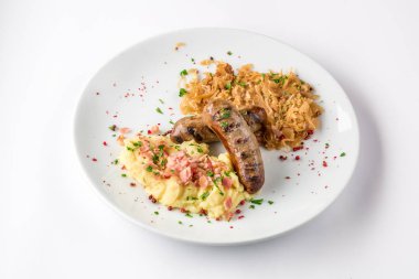 Sosis, patates ve beyaz tabak yakından görmek yukarıda üzerinde kızarmış lahana ızgara.