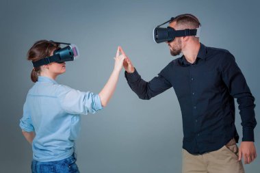 Genç çift gri arka plan üzerinde VR kulaklık kullanarak