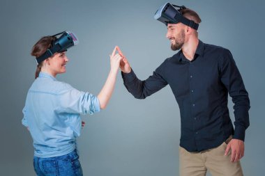 Genç çift gri arka plan üzerinde VR kulaklık kullanarak