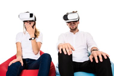 Sanal gerçeklik beyaz arka plan üzerinde izole beanbags üzerinde oturmuş yaşandığı heyecanlı genç Çift