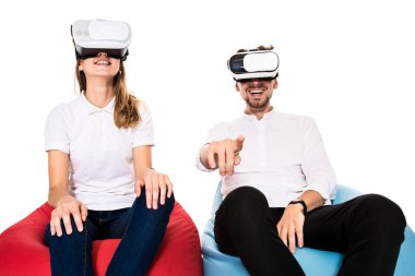 Sanal gerçeklik beyaz arka plan üzerinde izole beanbags üzerinde oturmuş yaşandığı heyecanlı genç Çift