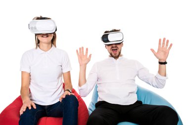 Sanal gerçeklik beyaz arka plan üzerinde izole beanbags üzerinde oturmuş yaşandığı heyecanlı genç Çift