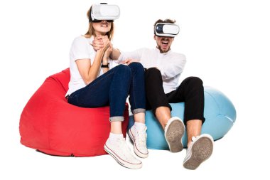 Sanal gerçeklik beyaz arka plan üzerinde izole beanbags üzerinde oturmuş yaşandığı heyecanlı genç Çift