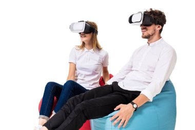 Sanal gerçeklik beyaz arka plan üzerinde izole beanbags üzerinde oturmuş yaşandığı heyecanlı genç Çift