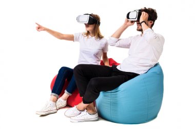 Sanal gerçeklik beyaz arka plan üzerinde izole beanbags üzerinde oturmuş yaşandığı heyecanlı genç Çift