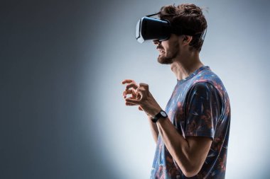Genç bir adam bir Vr kulaklık kullanarak yan görünüm. Duygular