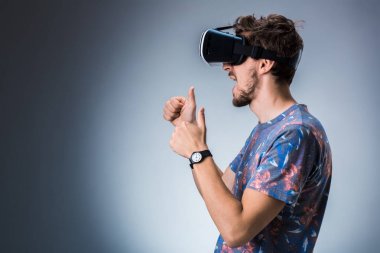 Genç bir adam bir Vr kulaklık kullanarak yan görünüm. Duygular