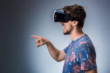 Genç bir adam bir Vr kulaklık kullanarak yan görünüm. Duygular
