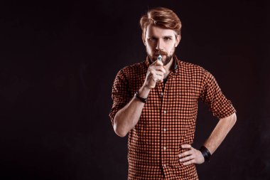 Genç adam elektronik sigara içiyor.