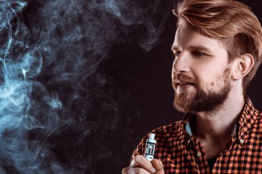 Genç adam elektronik sigara içiyor.