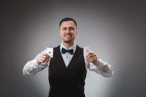 Молодий чоловік у сорочці та жилеті показує покерні картки, студійний знімок — стокове фото