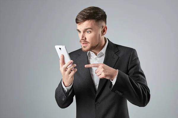 Retrato de un hombre de negocios guapo haciendo una llamada telefónica contra fondo gris —  Fotos de Stock