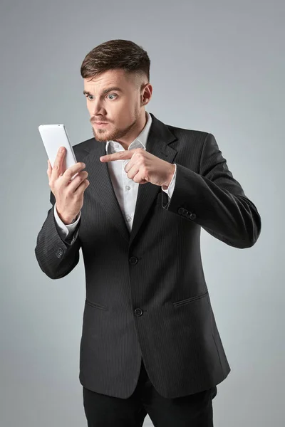 Retrato de un hombre de negocios guapo haciendo una llamada telefónica contra fondo gris —  Fotos de Stock