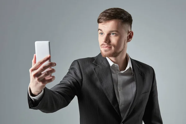 Empresario en un traje negro hace la selfie en el teléfono inteligente —  Fotos de Stock