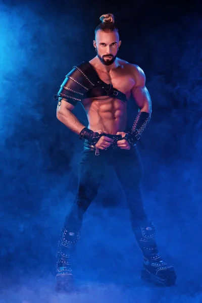 Handsome young sexy man with beautiful muscular chest in interesting costume on the scene — Stock Photo, Image