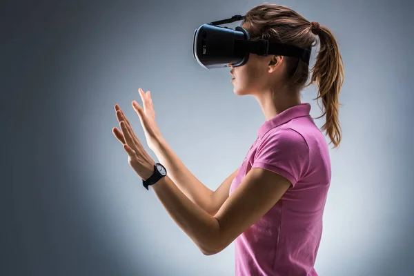 Giovane donna che indossa cuffie realtà virtuale in studio. Emozioni. Vista laterale — Foto Stock