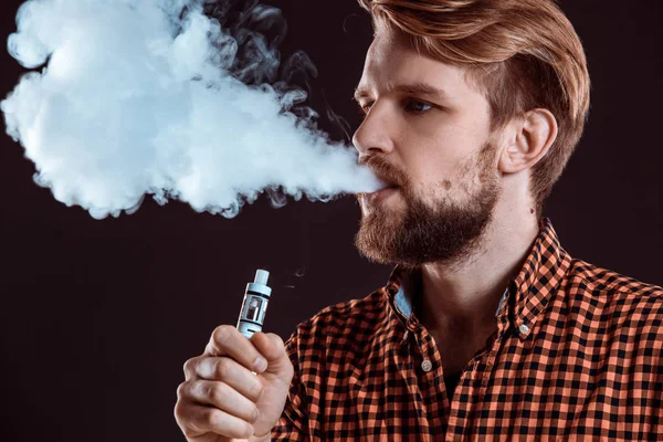 Young man smoking electronic cigarette — Stock Photo, Image