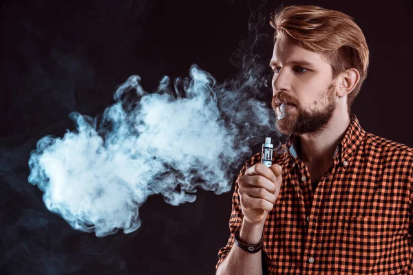 Young man smoking electronic cigarette — Stock Photo, Image