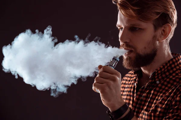 Young man smoking electronic cigarette — Stock Photo, Image
