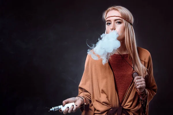 Mujer joven en el estilo Boho soplando humo — Foto de Stock